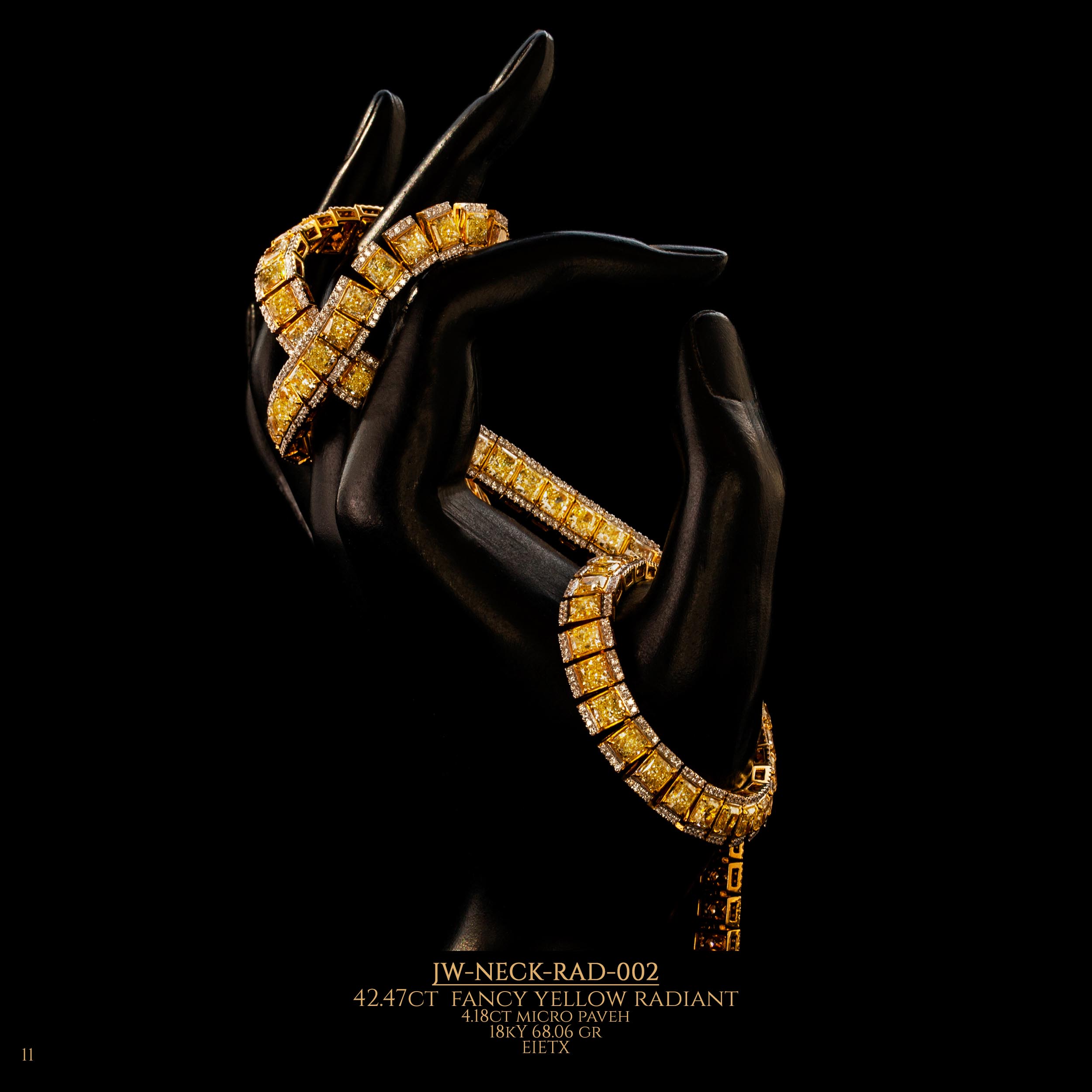 Bracelet with fancy yellow diamonds wrapped over the fingers of a doll's hand.