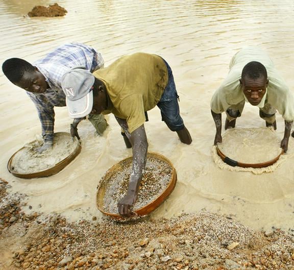 Artisanal diamond miners panning for rough gems in Sierra Leone
