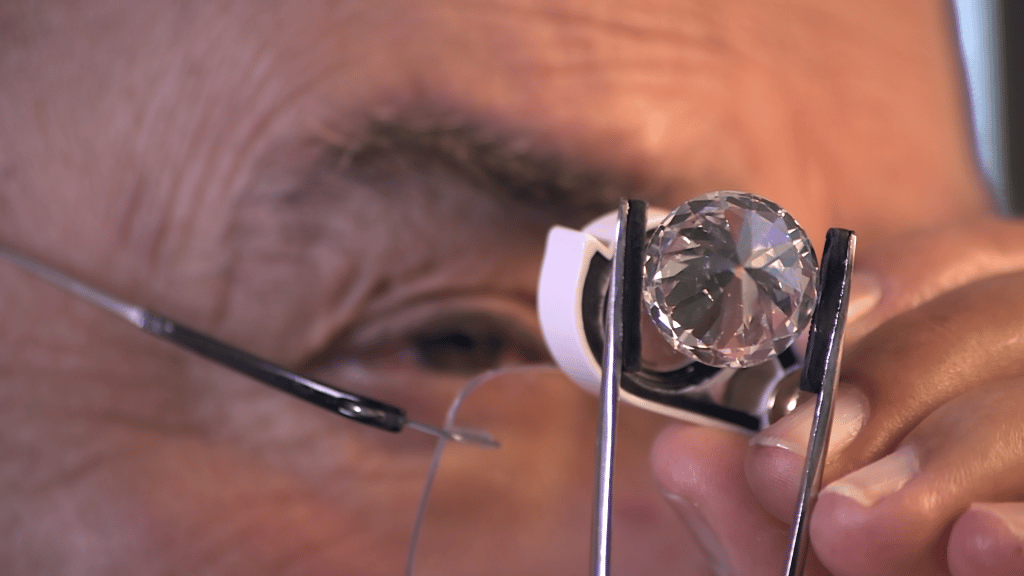 Benny Meirov - Diamond expert inspecting gemstone through magnifying loupe
