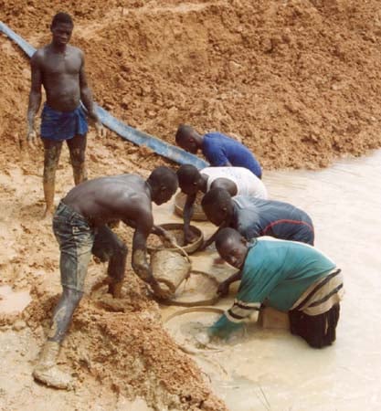 Artisanal miners extracting resources in dusty landscape