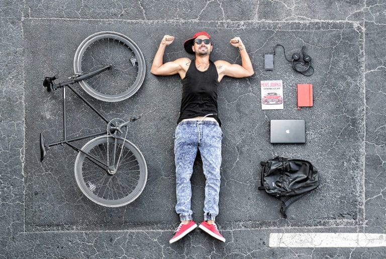 A man is lying next to a bicycle and a variety of technological waves